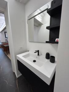 a bathroom with a white sink and a mirror at La casa Arancio in Ferrara +18 photos