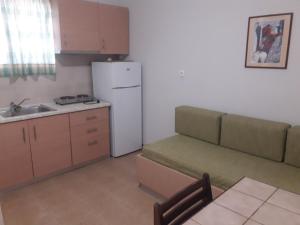 a small kitchen with a couch and a refrigerator at olivensun apartment 2 in Gythio