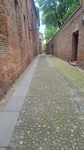 an empty alleyway between two brick buildings at La casa Arancio in Ferrara