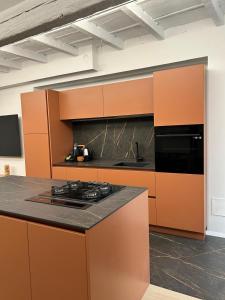 a kitchen with orange cabinets and a black counter top at La casa Arancio in Ferrara