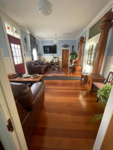 a living room with a couch and a hard wood floor at Rose Lodge Bed & Breakfast in Tirau