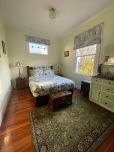 a bedroom with a bed and a rug at Rose Lodge Bed & Breakfast in Tirau