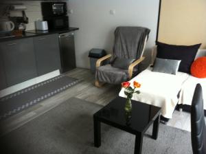 a living room with a couch and a chair and a table at Carpe Diem Résidence in Plombières-les-Bains