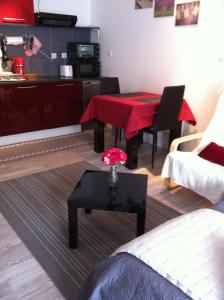 ein Wohnzimmer mit einem Tisch und einer Küche in der Unterkunft Carpe Diem Résidence in Plombières-les-Bains