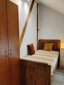a bedroom with a bed and a wooden cabinet at Apartamentai Heydekrug in Šilutė
