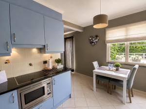 a kitchen with blue cabinets and a table and a table and chairs at B&B Aline Florentine - adults only - Luxury B&B - Chambres d'Hôtes - Zimmer Frei - Short Stay in Kortenberg