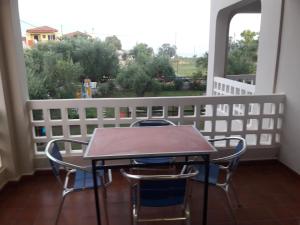 a table and chairs on a balcony with a window at olivensun apartment 2 in Gythio +3 photos
