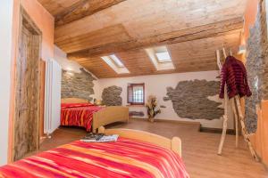 a bedroom with two beds and a stone wall at Locanda Il Campo della Quercia in San Damiano Macra