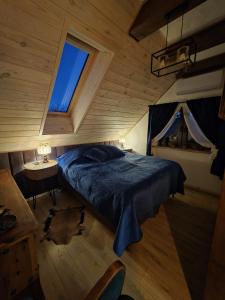a bedroom with a blue bed and a window at Woodland Apartment Small in Berezka