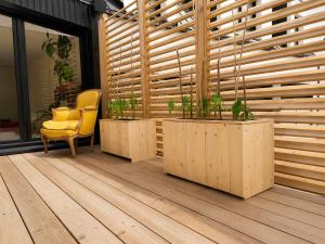 a room with a yellow chair and a wooden wall at Near Train Station in Rennes