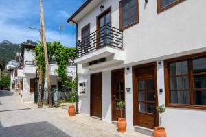 a white building with wooden doors on a street at VillAge 1912 Studios in Panagia