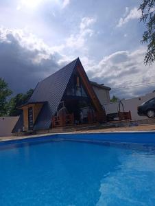 ein Haus mit Satteldach neben einem Swimmingpool in der Unterkunft Vila Markizo in Barajevo