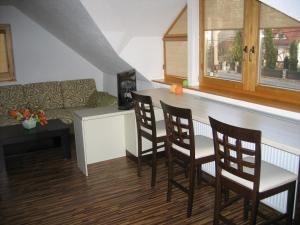 a kitchen with a bar with chairs and a couch at Apartmán Ria in Hriňová