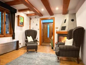 a living room with two chairs and a fireplace at Red Lake Inn in Gheorgheni