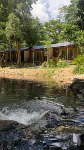a building next to a body of water at ลิตเติ้ล แคมป์ ชะอม in Ban Bung Mai