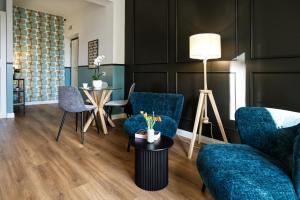a living room with blue chairs and a table at Savi Guest House metro B S Paolo in Rome