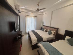 a hotel room with two beds and a tv at Hotel Narayan free Parking & Near Toran Dwar in Khātu