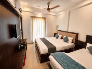 a hotel room with two beds and a flat screen tv at Hotel Narayan free Parking & Near Toran Dwar in Khātu
