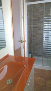 y baño con lavabo de color naranja y ducha. en Mediterraneo, en Masnou