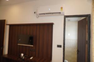 a room with a door and a television on a wall at Hotel Narayan free Parking & Near Toran Dwar in Khātu +55 photos