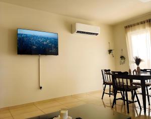 a living room with a flat screen tv on the wall at Stay in Harmony in Paralimni