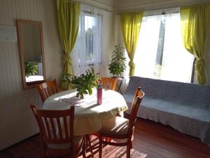 a dining room with a table and chairs and a couch at Refugio Pradera del Sur in Llanquihue