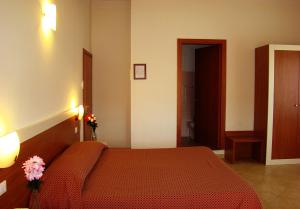 a bedroom with a bed with a red bedspread at B&B Soggiorno Ponte Rosso in Florence