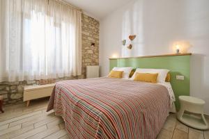 a bedroom with a large bed with a green headboard at OlioeAlloro B&B in San Vincenzo