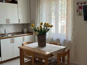 a kitchen table with a vase of flowers on it at Appartamento Ortensia in Fetovaia