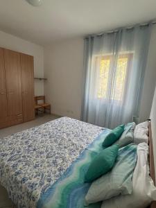 a bedroom with a bed and a window at Appartamento Ortensia in Fetovaia