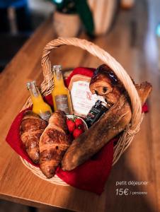 a basket of bread and pastries on a table at Chalet romantique - Jacuzzi privatif - King size in Montignac-Charente