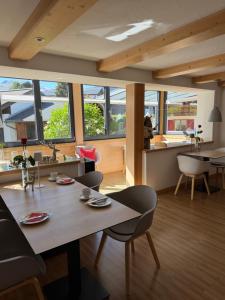 a living room with a table and chairs and windows at Hotel Engel in Oberstdorf