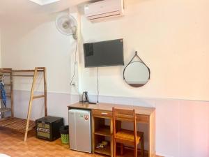 a room with a desk and a tv on the wall at Bungalow COCO CHILL PQ in Phú Quốc