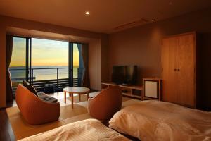 a bedroom with a bed and a view of the ocean at ゆうみ in Kyonan