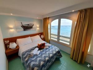 a bedroom with a bed and a large window at Casa Vacanze Elianto in Anzio