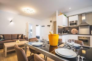 a kitchen and living room with a table and chairs at Lys Appart in Reims