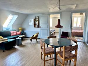 a living room with a table and a couch at Groland Bornholm B&B in Pedersker