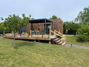a small house with a deck with a table at Gîte de la Vigne in Ley