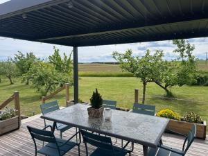 a table and chairs on a wooden deck with a view of a field at Gîte de la Vigne in Ley