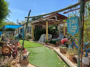 a backyard with a garden with a wooden pergola at negev ein habsor עין הבשור דרום in Ein HaBesor