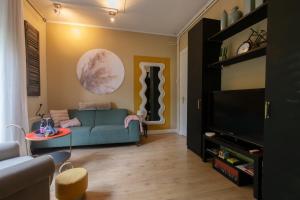 a living room with a blue couch and a tv at Studio Unique in Enschede