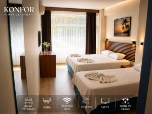 a hotel room with two beds and a window at Blue Park Beach Otel in Ayvacık