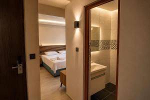 a bedroom with a bed and a bathroom with a shower at Blue Park Beach Otel in Ayvacık