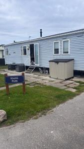 a mobile home with a sign in front of it at Lyons Robin Hood Hazel Park 6 in Rhyl