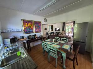 a kitchen and living room with a table and chairs at Next to Heaven Guesthouse in Stormsrivier