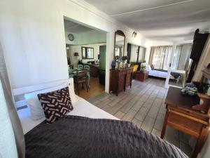 a bedroom with a bed and a living room at Next to Heaven Guesthouse in Stormsrivier