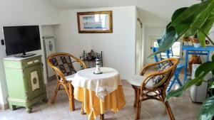 uma sala de jantar com mesa e cadeiras e uma televisão em B&B Marina Piccola em Vieste