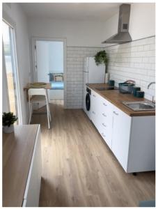 a kitchen with a sink and a refrigerator and a table at Siorica AG Low Cost in Matalascañas +4 photos