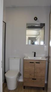 a bathroom with a toilet and a sink and a mirror at Siorica AG Low Cost in Matalascañas