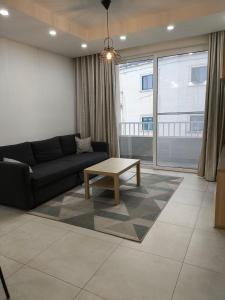 a living room with a couch and a coffee table at Link Point -Private room in shared Apartment in Misraħ Il-Barrieri